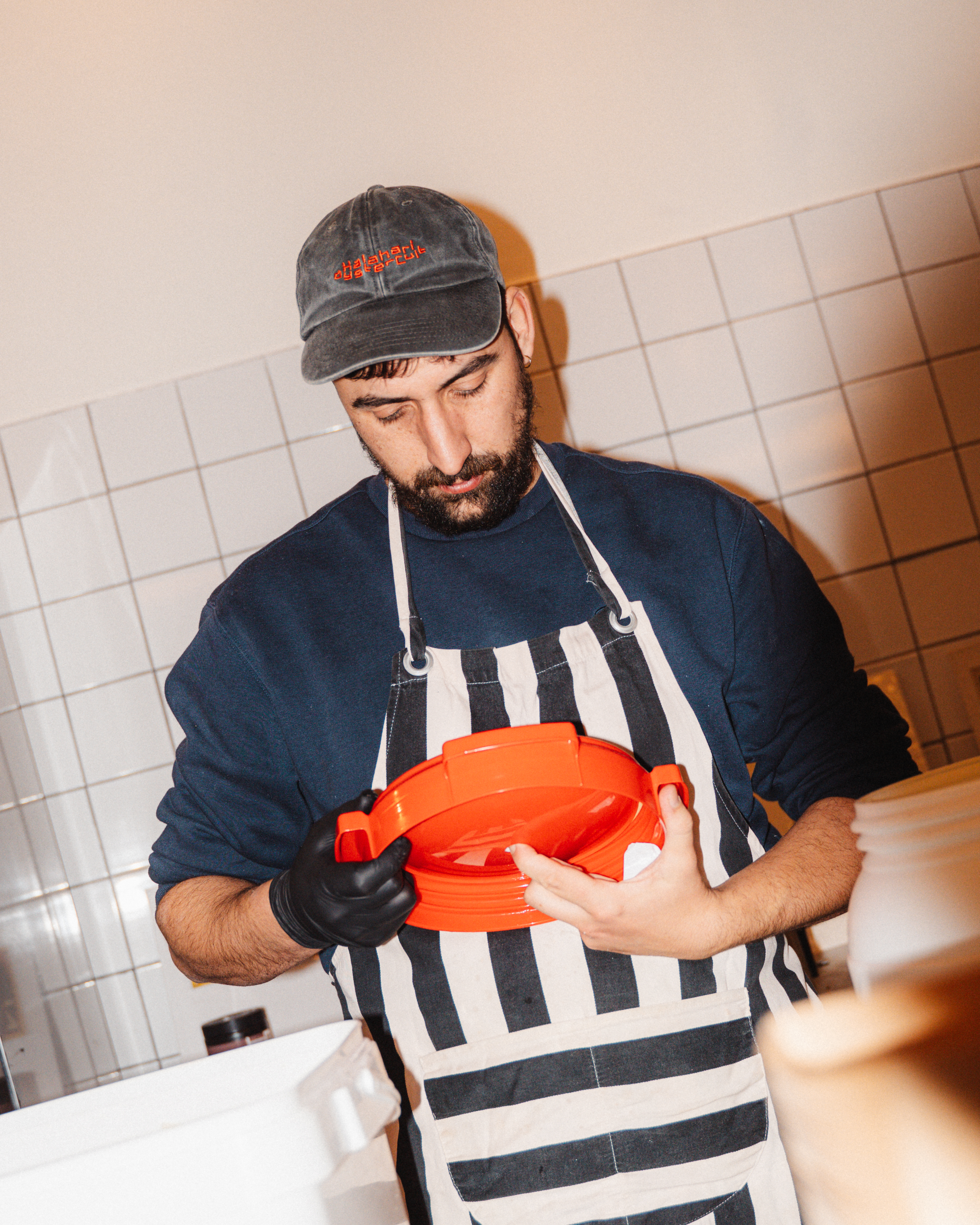 man met een rood deksel in zijn handen